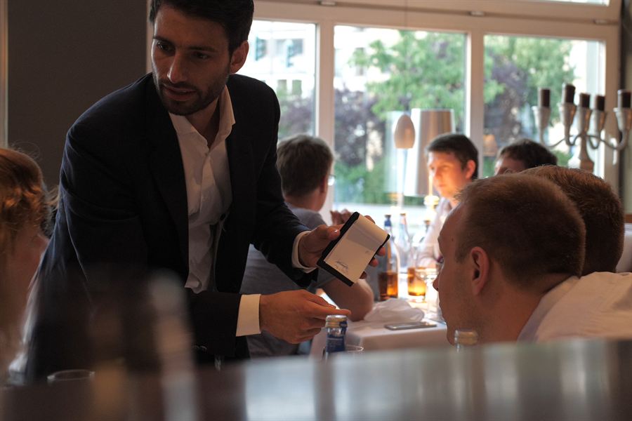 Close-up-Magie im Restaurant: Oliver Henke zeigt Gästen am Tisch ein Kunststück
