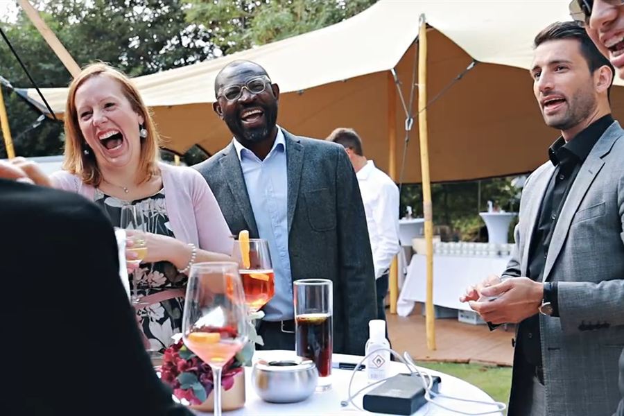 Hochzeit im Freien: Gäste lachen bei einem Kunststück von Oliver Henke
